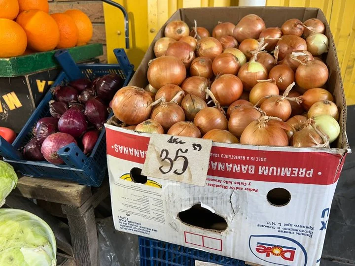 Жовта ріпчаста цибуля в ящику з цінником 35 грн на ринку